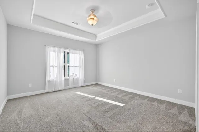 an empty room with windows and ceiling fan