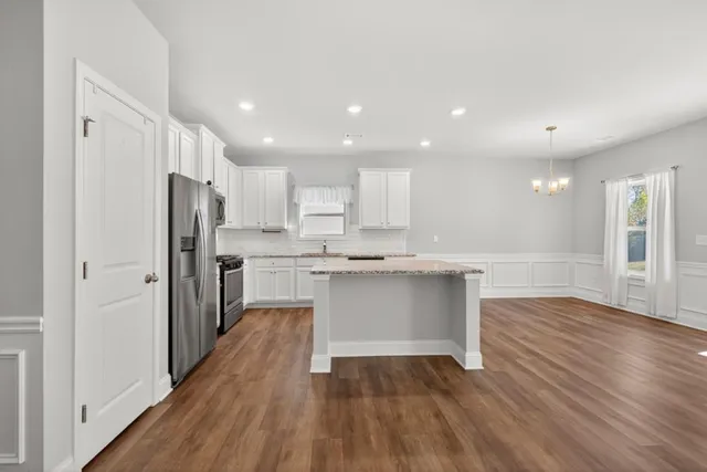 a kitchen with a refrigerator and white cabinets