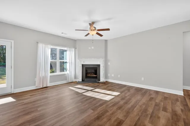 wooden floor fireplace and windows in an empty room