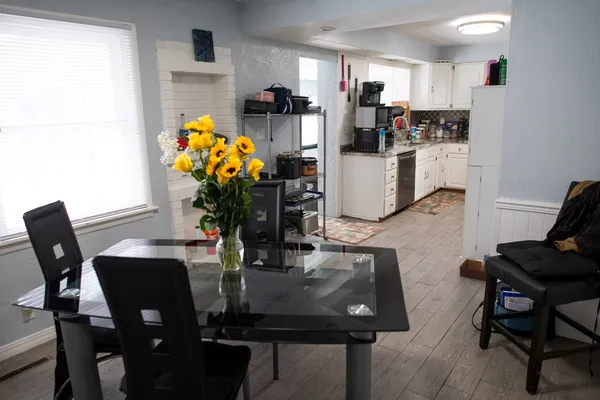 a kitchen with stainless steel appliances a dining table chairs and refrigerator