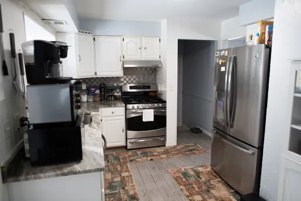 a kitchen with stainless steel appliances and refrigerator