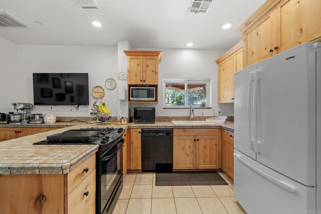 22002 Lyons Valley Road Alpine, CA 91901 - Photo 43 of 75 a kitchen with a sink stove and refrigerator