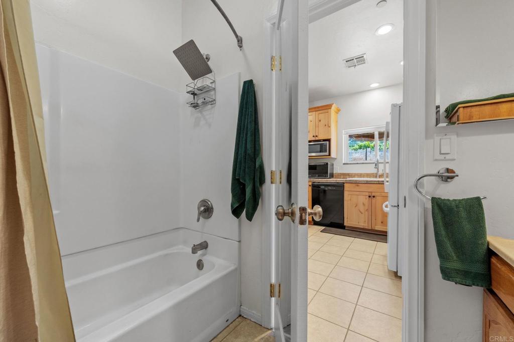 22002 Lyons Valley Road Alpine, CA 91901 - Photo 46 of 75 a bathroom with a tub a mirror and a shower