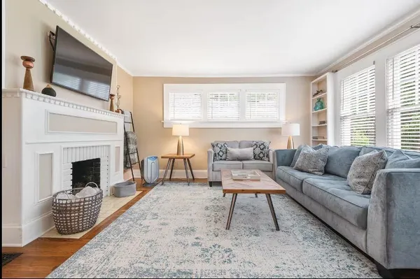 a living room with furniture a flat screen tv and a fireplace