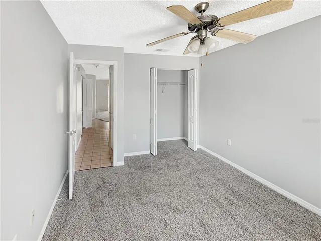 an empty room with fan and entryway