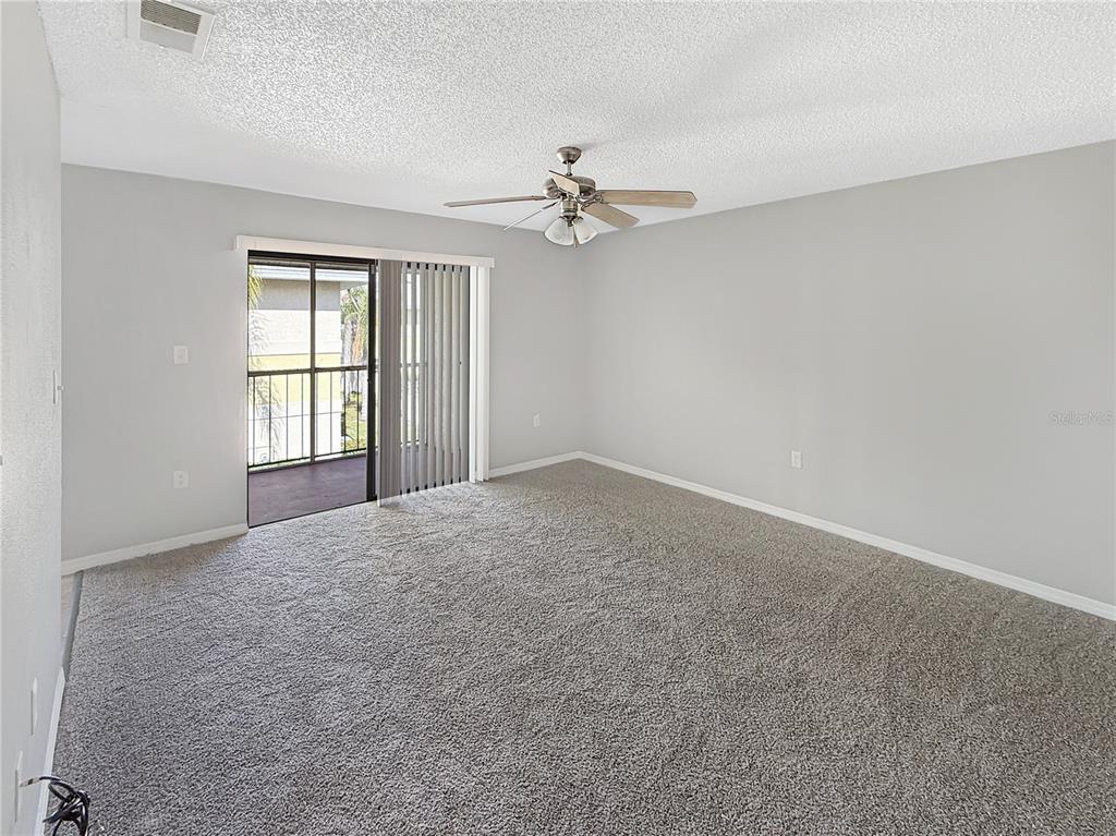90 Hidden Lake Drive, Unit 132 Sanford, FL 32773 - Photo 2 of 13 an empty room with chandelier fan and windows
