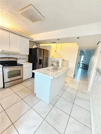a large white kitchen with a stove a sink and a microwave
