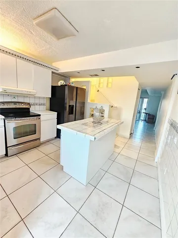 a large white kitchen with a stove a sink and a microwave