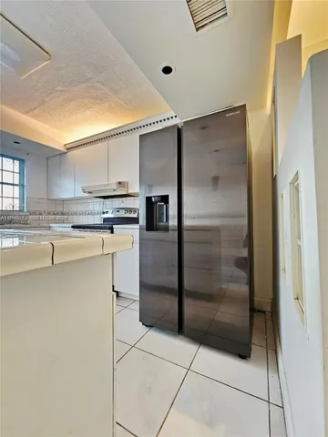 a kitchen with stainless steel appliances a refrigerator sink and cabinets