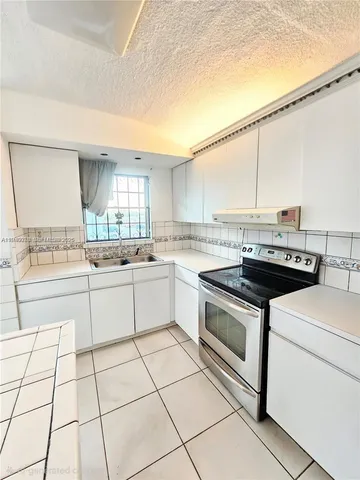 a kitchen with a stove a sink and a refrigerator