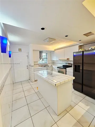 a large white kitchen with cabinets and a stainless steel appliances
