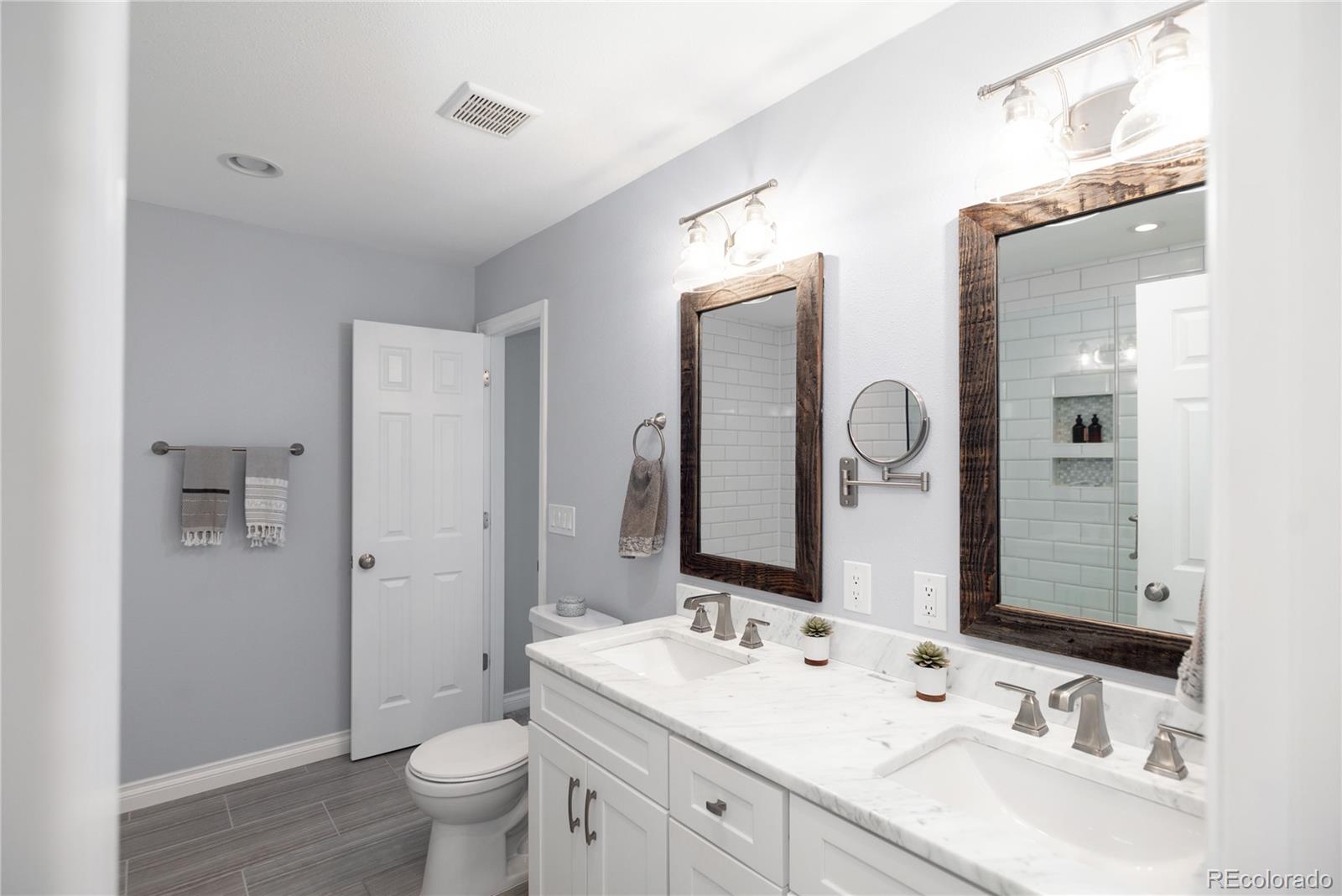 2696 Perry Street Denver, CO 80212 - Photo 25 of 40 a bathroom with a double vanity sink toilet mirror and shower