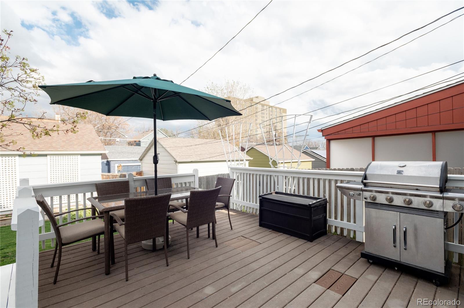 2696 Perry Street Denver, CO 80212 - Photo 39 of 40 a view of a roof deck with table and chairs under an umbrella with wooden floor