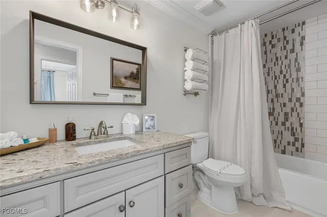 a bathroom with a granite countertop toilet sink and mirror