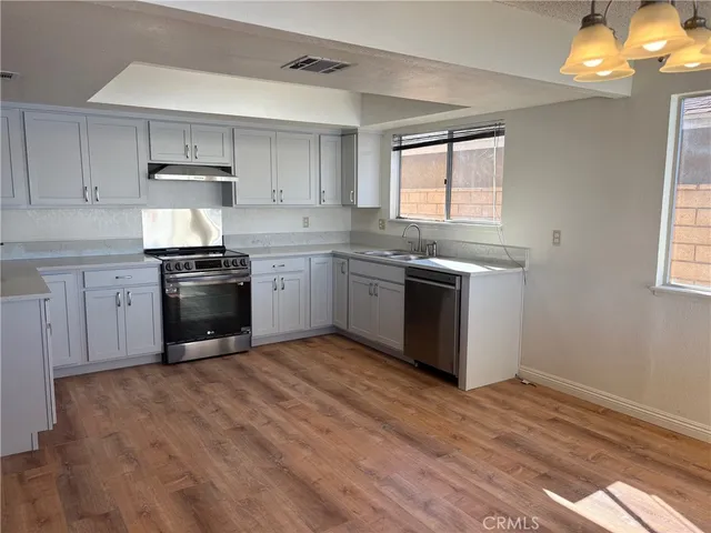 a kitchen with stainless steel appliances granite countertop a stove a sink and a microwave