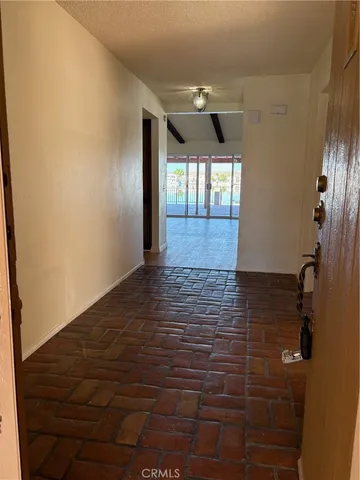 a view of hallway with window and wooden floor