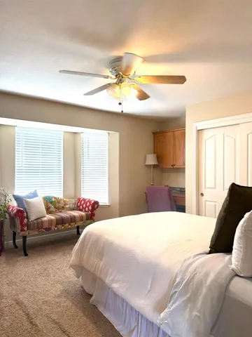 a spacious bedroom with a bed and a chandelier
