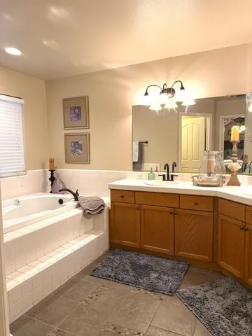 a spacious bathroom with a tub sink and mirror