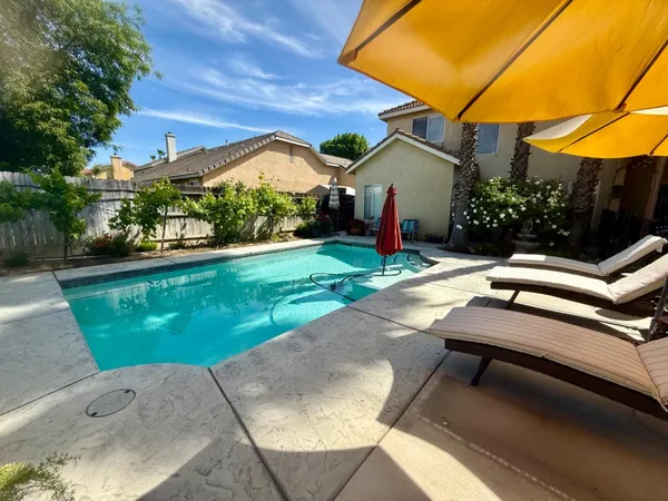 a view of backyard with swimming pool and outdoor seating
