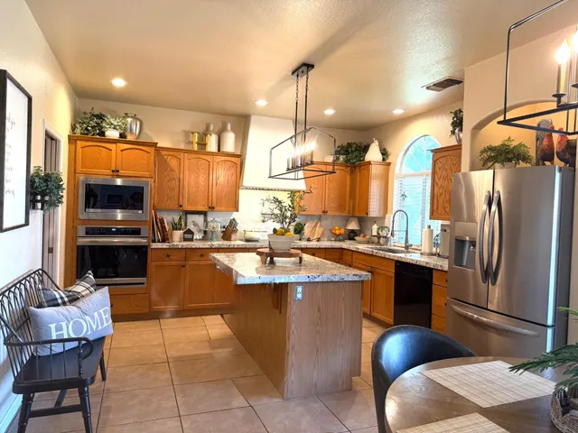a kitchen with stainless steel appliances granite countertop a sink a stove and a refrigerator