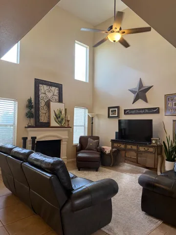 a living room with furniture a ceiling fan and a fireplace