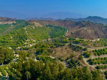 a view of a lush green mountain with a building in the background