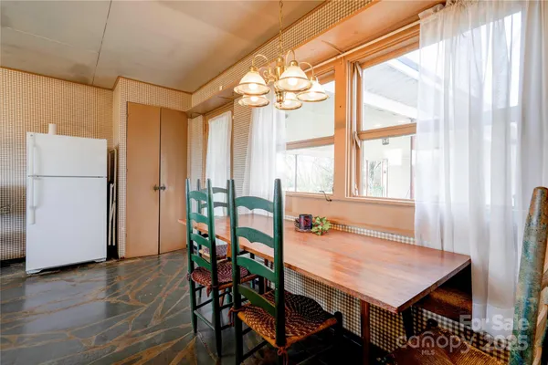 a dining room with furniture a chandelier and wooden floor