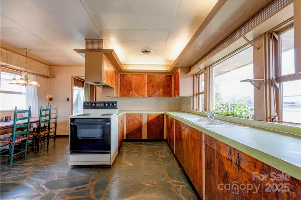 a large kitchen with stainless steel appliances granite countertop a stove and cabinets