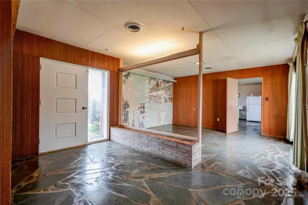a view of a livingroom with wooden floor and a bathroom