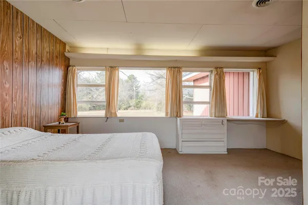 a living room with a dresser next to a window
