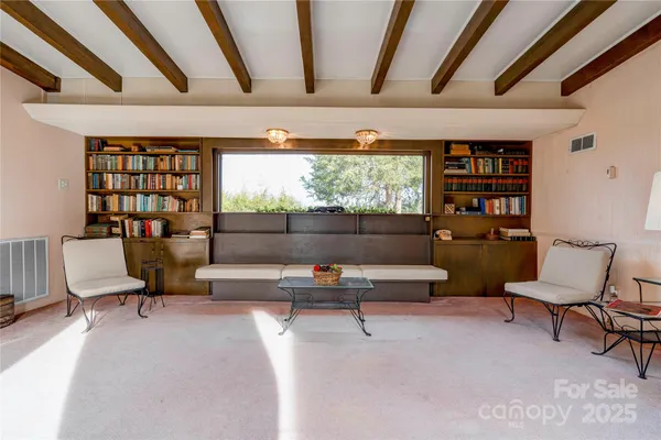 a living room with furniture a rug and a large window