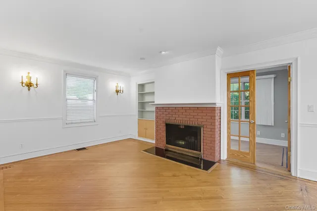 a living room with wooden floor and a fireplace