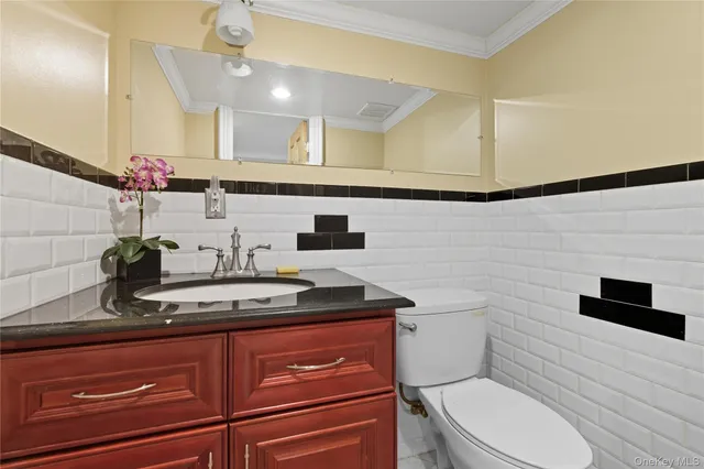 a bathroom with a granite countertop sink a toilet a mirror and shower