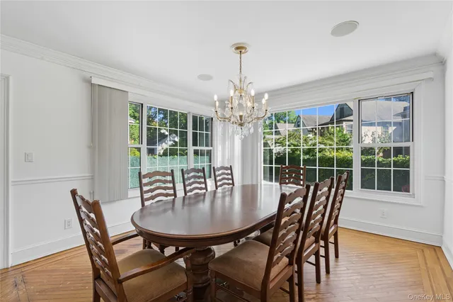 a dining room with furniture a chandelier and wooden floor