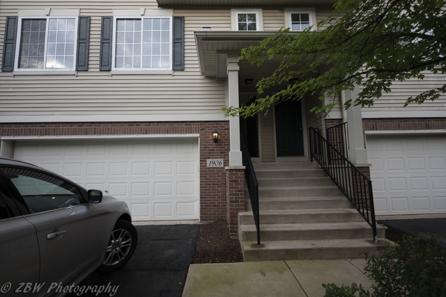1906 Indian Hill Lane, Unit 1906 Aurora, IL 60503 - Photo 1 of 13 a view of a house with wooden fence and large windows