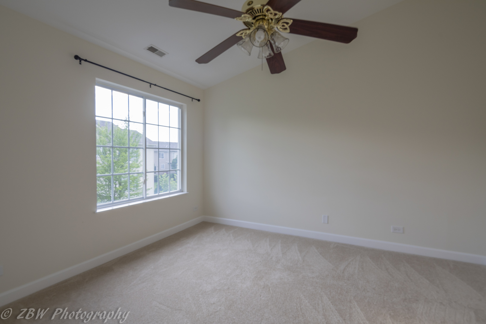 1906 Indian Hill Lane, Unit 1906 Aurora, IL 60503 - Photo 5 of 13 an empty room with a window and a fan