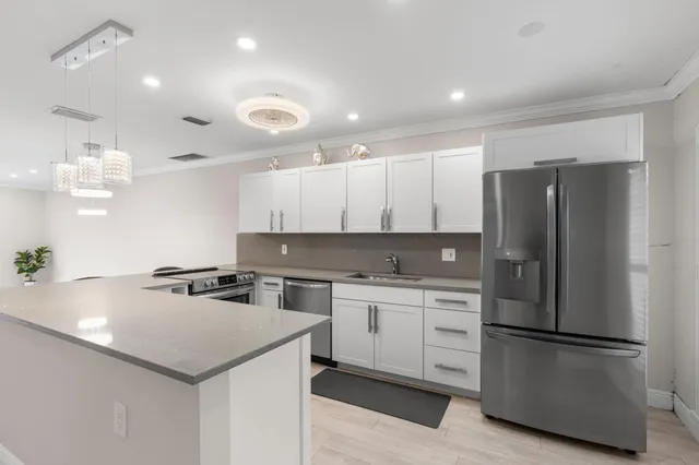 a kitchen with a white stove refrigerator and cabinets with wooden floor
