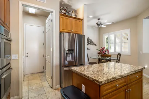 a kitchen with granite countertop kitchen island stainless steel appliances a refrigerator stove and sink