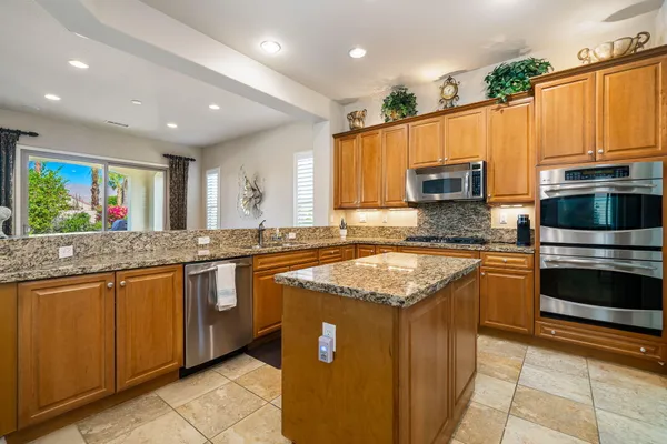 a kitchen with stainless steel appliances granite countertop a sink stove and microwave
