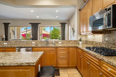 a kitchen with stainless steel appliances granite countertop a sink and a stove