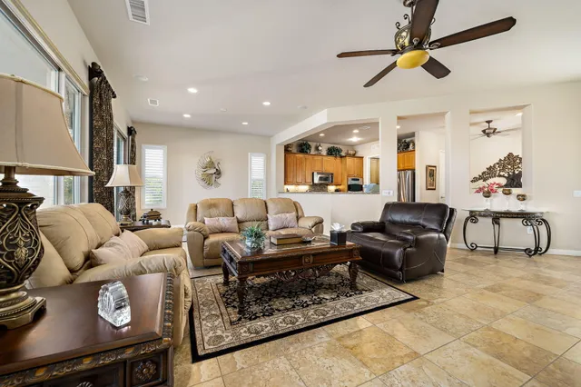 a living room with furniture and a ceiling fan