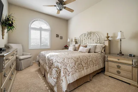 a spacious bedroom with a bed and a chandelier