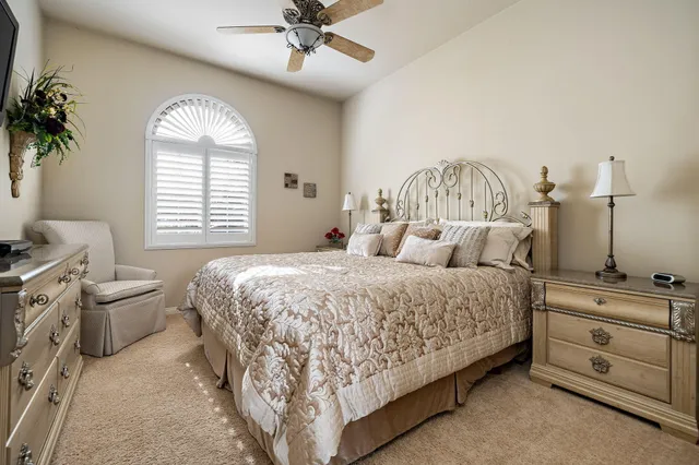 a spacious bedroom with a bed and a chandelier