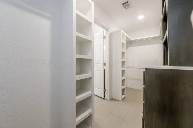 a view of walk in closet with empty racks