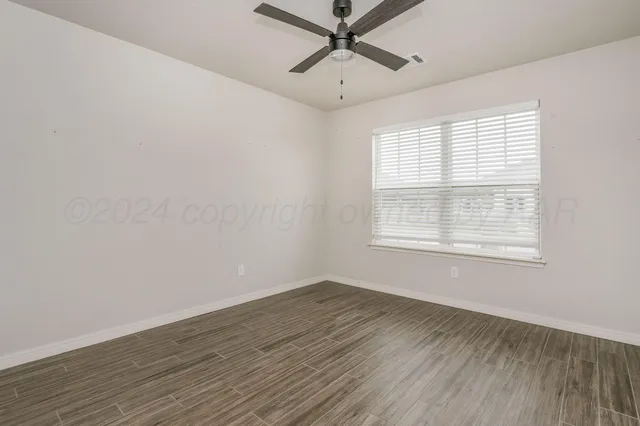 a view of a room with wooden floor and windows