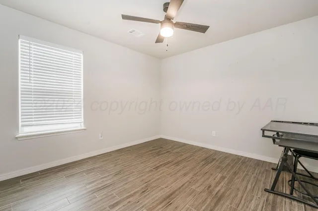 a view of a workspace with wooden floor and a window