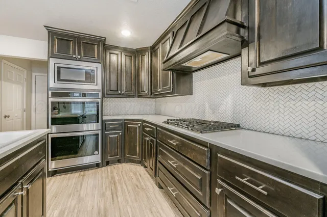 a kitchen with granite countertop stainless steel appliances and wooden cabinets