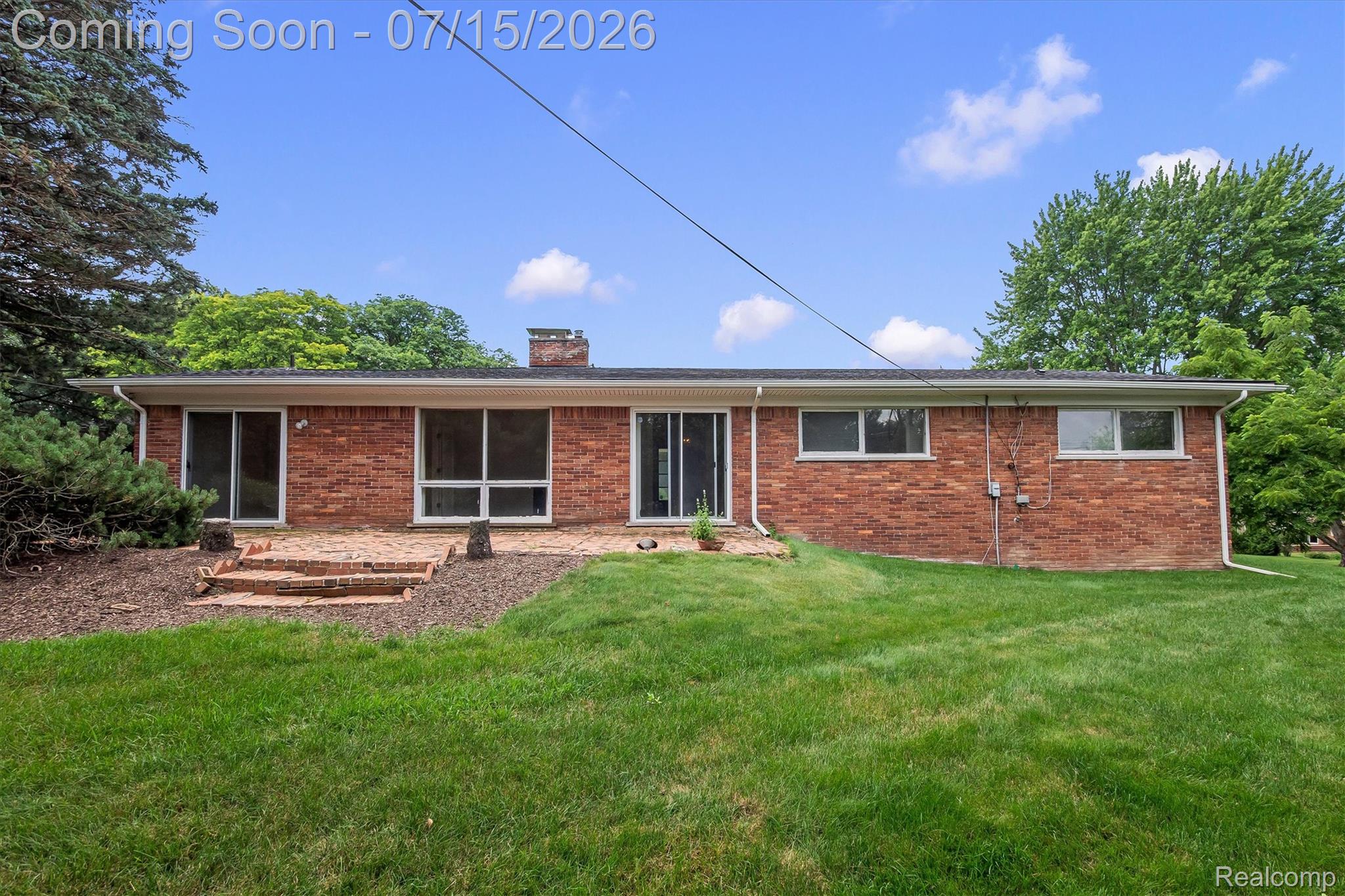 1151 Peveril Road Bloomfield Hills, MI 48304 - Photo 36 of 39 Brick exterior with multiple sliding glass doors, large windows and a brick patio