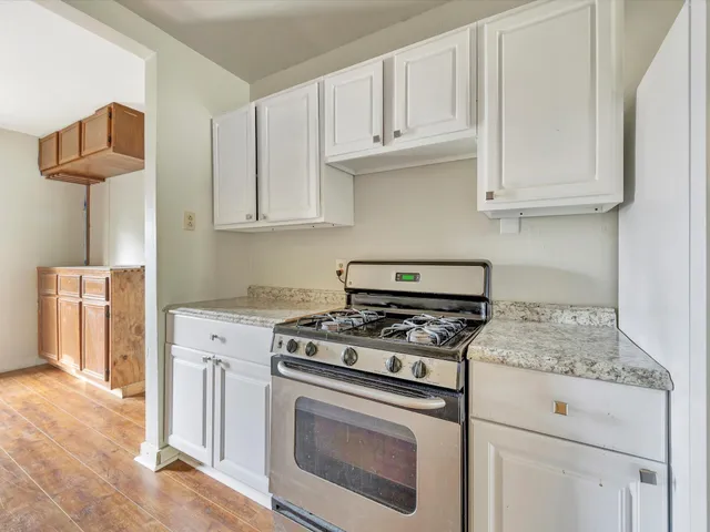 a kitchen with granite countertop white cabinets and white appliances
