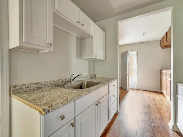 a kitchen with granite countertop a sink and a stove